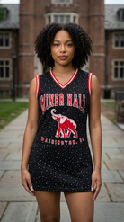 Woman wearing a black and red 'Miner Hall' dress with an elephant logo in front of a brick building.