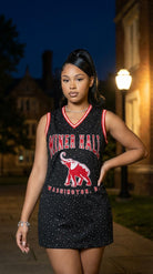 Woman wearing a black and red 'Miner Hall' dress with an elephant graphic at night.